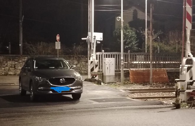 L'auto ferma tra i binari del passaggio a livello della stazione di Cocquio (foto tratta da Sei di Cocquio se)