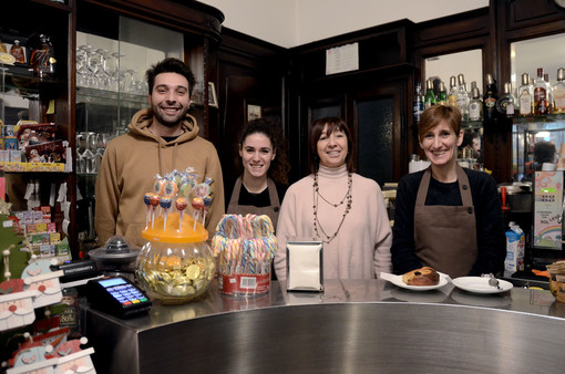 L'epopea della Pasticceria Ghezzi, in corso Matteotti, prosegue grazie a Gabriela, terza da sinistra e nipote del fondatore Carlo Ghezzi: in foto è insieme al figlio Matteo Marelli e alla collaboratrici Alice e Marta. Sotto in gallery Matteo con la nonna Maria e il Ghezzi dipinto da Manuela Vasconi