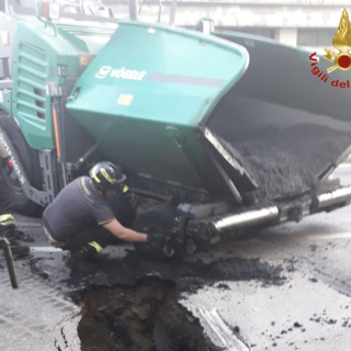 FOTO. Sesto Calende, macchina asfaltatrice finisce nella voragine in strada