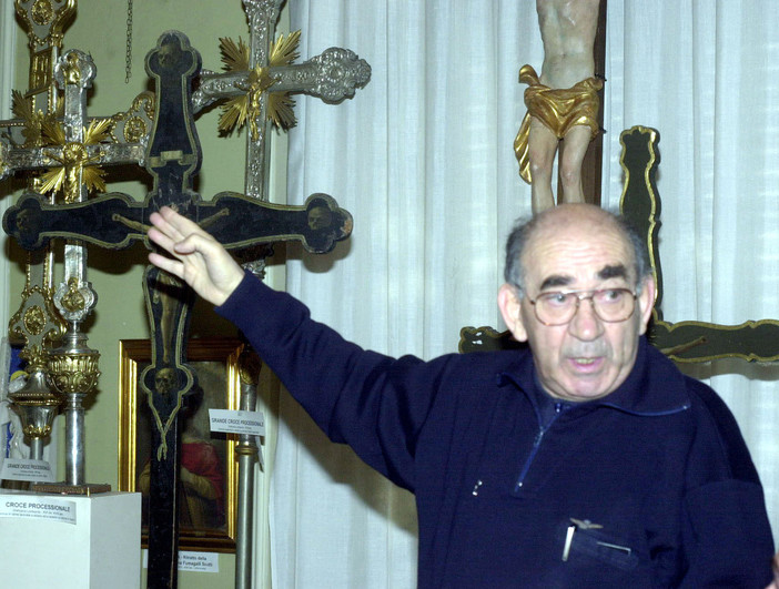 Don Luigi Brambillasca fotografato da Daniele Belosio mentre indica la Croce nella sua chiesa