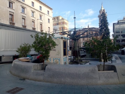 Luci e addobbi natalizi in allestimento in piazza Monte Grappa sotto un sole primaverile