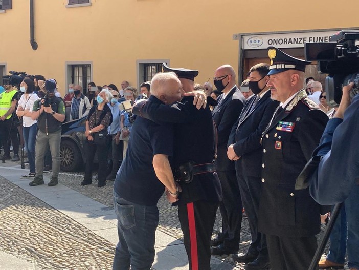 Nonno Giulio abbraccia i carabinieri, sotto la folla e i feretri