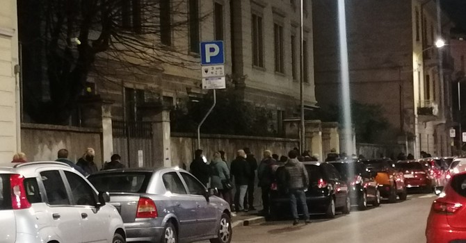 Le persone in coda in via Bernardino Luini in attesa dei pasti preparati dalle suore della Riparazione